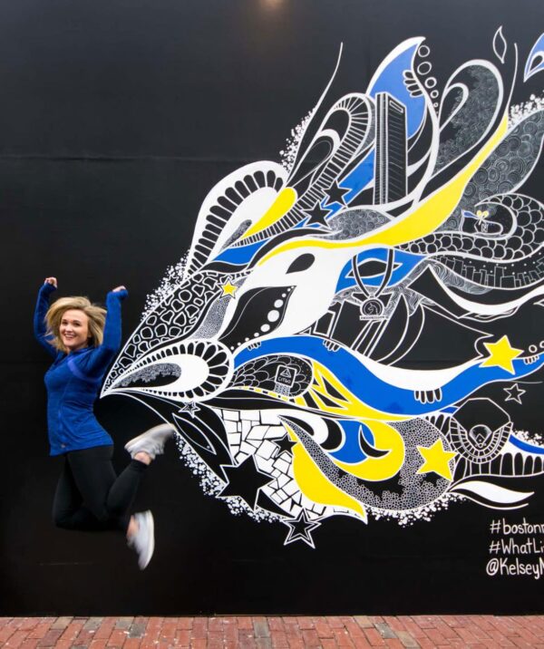 Catering Sales Manager, Taylor Marshall, poses in front of the finished Marathon Mural