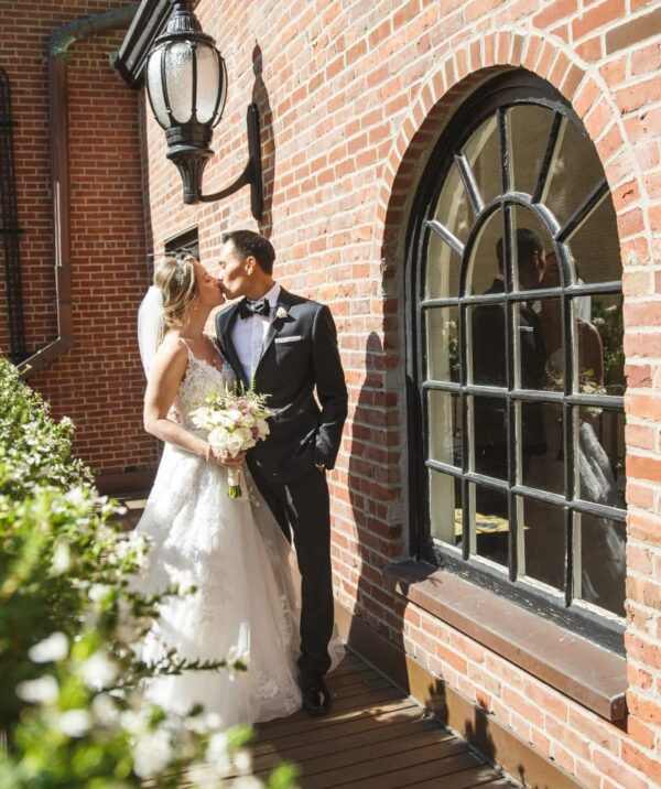 Wedding couple on veranda outside of Dome Room with flowers