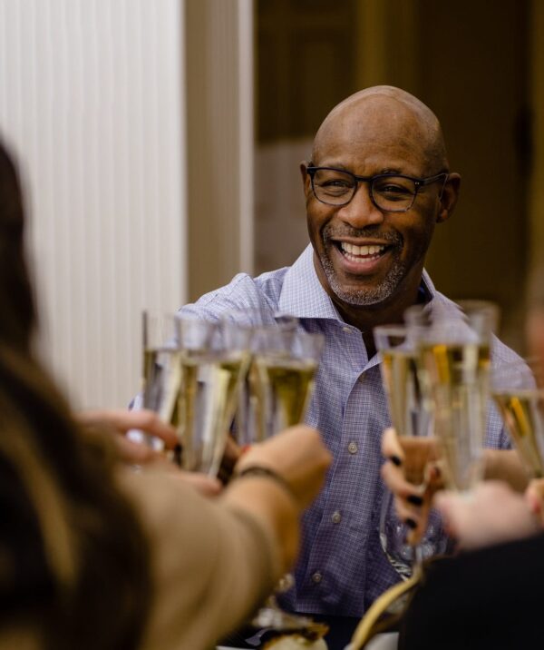 Man toasting group of people with champagne glasses